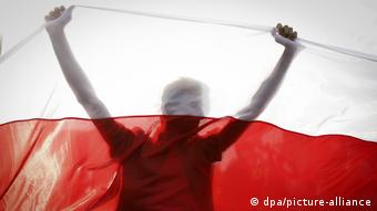 Участник протестов в Минске с белорусским флагом