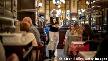 PARIS, FRANCE - OCTOBER 10: A waiter during service at the Chartier Bouillon Restaurant near Grands Boulevards on October 10, 2020 in Paris, France. The restaurant, founded in 1896, famously had been open every day since, until the Covid-19 national French lockdown earlier this year when the restaurant was forced to shut for the first time in its 120 year history. Observing strict social distancing regulations the restaurant is running at less than 50% capacity, from an average of two thousand covers a day to now under one thousand. (Photo by Kiran Ridley/Getty Images)