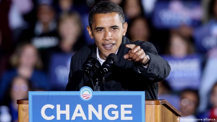 Barack Obama beim Wahlkampf in Virginia 2008, er steht an einem Rednerpult mit der Aufschrift Change und streckt seinen Zeigefinger optimistisch in Richtung Kamera