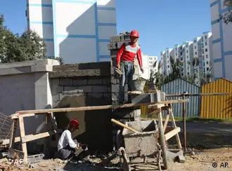 This Oct. 11, 2009 photo shows Chinese workers building a wall at a housing project funded by the Algerian government and built by a state-owned Chinese firm near Algiers, Algeria. While still struggling with the aftermath of a decade-long Islamic insurgency, oil-rich yet impoverished Algeria is getting a makeover: a new airport, its first mall, its largest prison, 60,000 new homes, two luxury hotels and the longest continuous highway in Africa. The power behind this runaway building spree is China. Some 50 Chinese firms, largely state-controlled, have been awarded $20 billion in government construction contracts, or 10 percent of the massive investment plan promised by President Abdelaziz Bouteflika for a nation where jobs and housing are scarce and al-Qaeda has struck roots. (AP Photo/Alfred de Montesquiou)