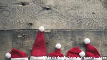 Santa Claus is coming, five hat of Santa on a rustic wooden background with space for text | Verwendung weltweit