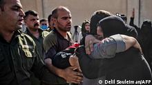 A man, suspected of having collaborated with the Islamic State (IS) group, is greetd by family members upon his release from the Kurdish-run Alaya prison in the northeastern Syrian city of Qamishli, on October 15, 2020. - The Syrian Democratic Forces (SDF) today released more than 600 Syrian prisoners in northern Syria who were being held there for acts of terrorism and alleged links with the Islamic State (IS) group. (Photo by Delil SOULEIMAN / AFP)