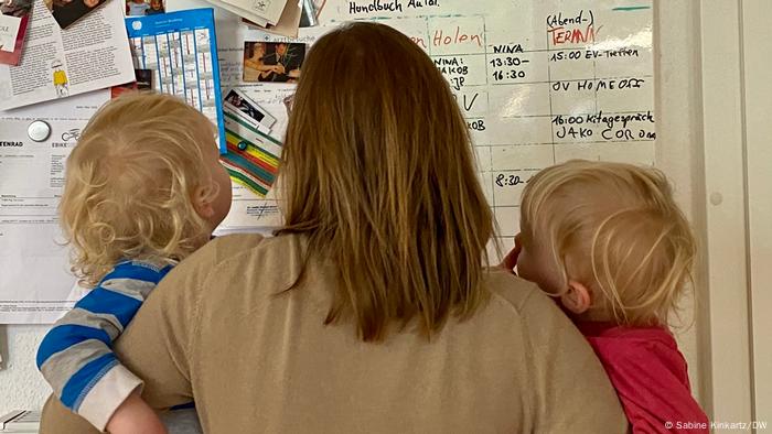 Deutschland Mutter mit Kindern vor Infotafel