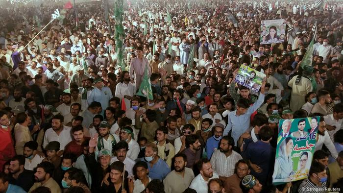 Supporters of Pakistan Democratic Movement (PDM), an alliance of political opposition parties, waves signs as they listen to their leaders during an anti-government protest rally in Gujranwala, Pakistan, October 16, 2020