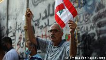 A man carries a flag and a noose during a demonstration marking one year since the start of nation-wide protests in Beirut, Lebanon October 17, 2020. REUTERS/Emma Freiha