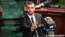 This picture taken on December 8, 2019 during a session of Tunisia's Assembly of Representatives shows Islamist Tunisian lawmaker Rached Khiari flashing a four-finger gesture used by Egypt's Muslim Brotherhood invoking Rabia, the name and number four in Arabic, recalling the mass-killing of protesters in the aftermath of the 2013 overthrow of Islamist President Mohamed Morsi. (Photo by FETHI BELAID / AFP)