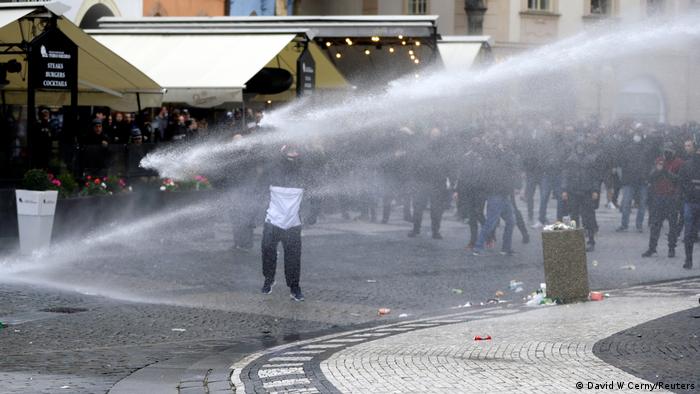 Riot police use water cannons during a protest in Prague against the Czech government's coronavirus restrictions 