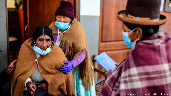 Mujeres indígenas en Huraina, Bolivia, esperan para ser vacunadas.