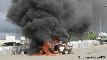Une voiture brûlée par des manifestants contre un troisième mandat d’Alassane Ouattara à Abidjan, le 19 octobre