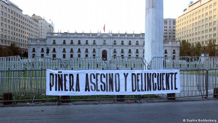 Piñera ist ein Mörder und Krimineller steht auf diesem Plakat vor dem Regierungspalast La Moneda