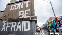 19.10.2020, Dublin, Irland, A pedestrian walks past a mural reading Don't Be Afraid in Dublin on October 19, 2020, amid reports that further lockdown restrictions could be imposed to help mitigate the spread of the novel coronavirus. - Ireland will crank up coronavirus restrictions, prime minister Micheal Martin said last week, announcing a raft of new curbs along the border with the British province of Northern Ireland. (Photo by Paul Faith / AFP) (Photo by PAUL FAITH/AFP via Getty Images)