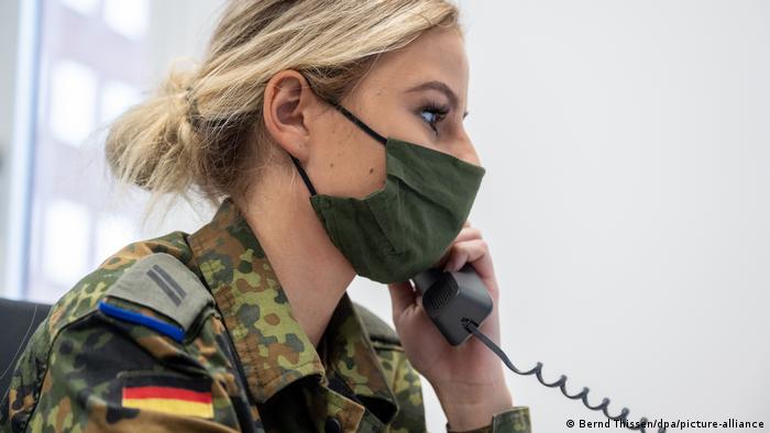 A German soldier makes a phone call to a person possibly infected with COVID