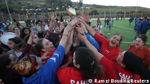 Women soccer team lift the trophy as they celebrate winning in an annual local soccer tournament played by an all women teams, at the village of Sahel, in the mostly Berber Kabylie region in the mountains east of Algiers, Algeria October 16, 2020. Picture taken October 16, 2020. REUTERS/Ramzi Boudina
