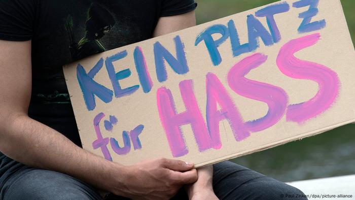 Jemand hält ein Schild mit der Aufschrift Kein Platz für Hass