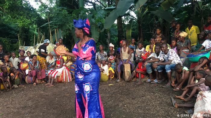 Rugiatu Turay stands in front of a group of people playing instruments