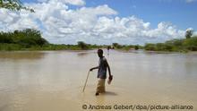 Ein Mann geht in einem Flüchtlingslager in der Nähe von Dadaab an der Grenze von Kenia zu Somalia durch das Wasser (Foto vom Oktober 2006). Bei starken Regenfällen wurde ein großer Teil des Landes im und um das Flüchtlingslager herum überschwemmt. In dem Flüchtlingslager sind hauptsächlich Menschen aus dem vom Bürgerkrieg zerütteten Somalia untergebracht. Foto: Andreas Gebert +++(c) dpa - Report+++ | Verwendung weltweit