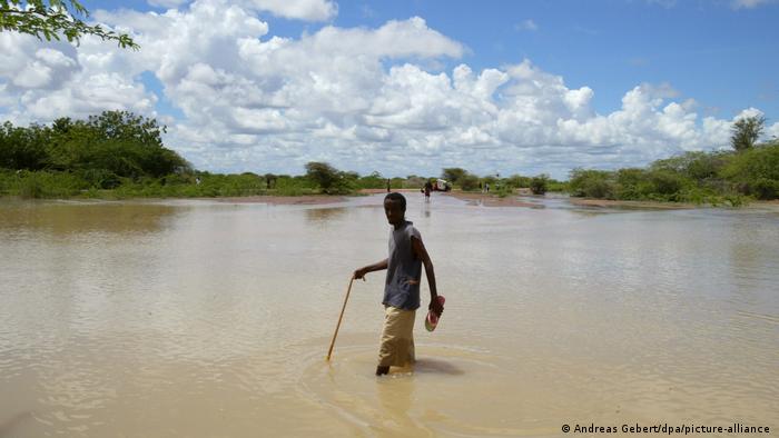 Ein Mann steht knietief auf einer überschwemmten Strasse Kenia Flüchtlingslager Dadaab