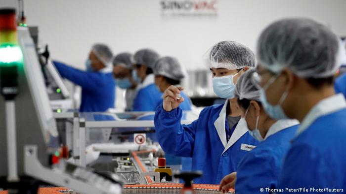 People work in the packaging facility of Chinese vaccine maker Sinovac Biotech