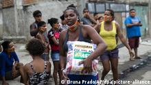 16.10.2020, Brasilien, Rio De Janeiro: Eine Frau trägt einen Sack mit gespendeten Lebensmitteln. Besonders arme Menschen sind aufgrund der Coronavirus-Pandemie von sinkenden Löhnen und Arbeitslosigkeit betroffen. Foto: Bruna Prado/AP/dpa +++ dpa-Bildfunk +++ |