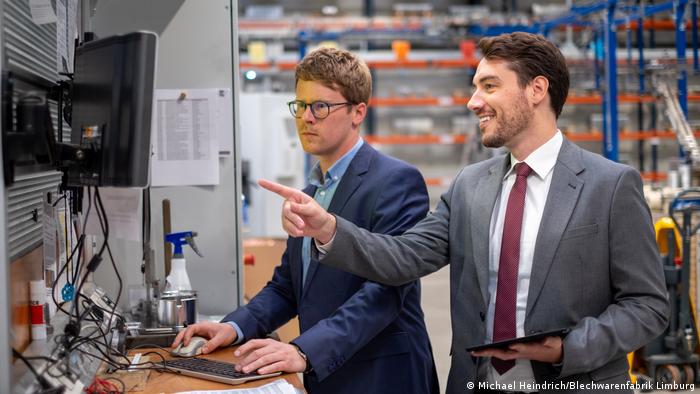 Umweltpreisträger Hugo Sebastian Trappmann überprüft mit einem Mitarbeiter eine Maschine in der Blechwarenfabrik Limburg