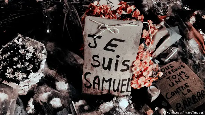 Placas escrito em francês e flores em homanegem a Paty. 