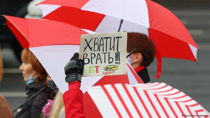 Участницы акции протеста в Минске с бело-красно-белыми зонтами Участницы акции протеста в Минске с бело-красно-белыми зонтами