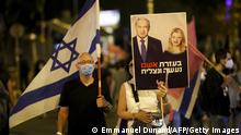 A protester lifts a placard depicting Israeli Prime Minister Benjamin Netanyahu and his wife Sarah during a demonstration near his residence in Jerusalem, on October 24, 2020. (Photo by EMMANUEL DUNAND / AFP) (Photo by EMMANUEL DUNAND/AFP via Getty Images)