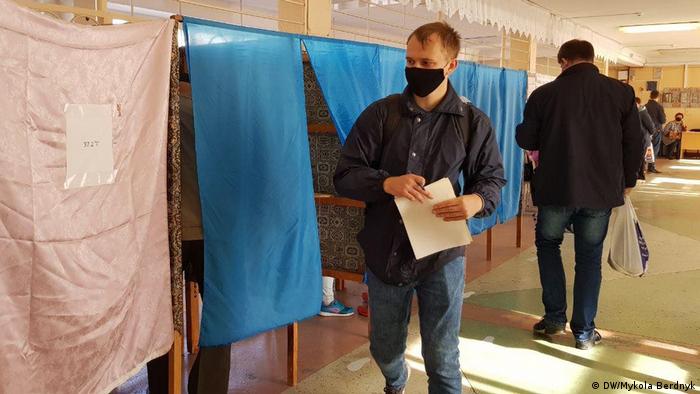 Мужчина с бюллетенем на одном из избирательных участков Киева