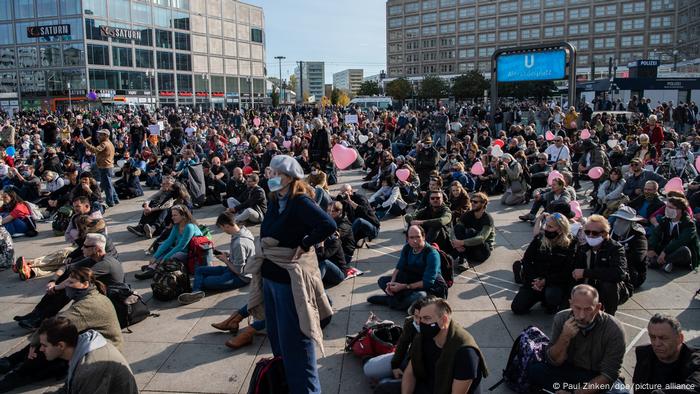 Protesters sit on the ground at Alexanderplatz in central Berlin (Paul Zinken/dpa/picture alliance)