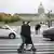 Two people ride a scooter in masks in Paris