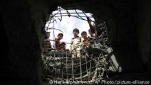 FILE - In this Wednesday, March 23, 2016 file photo, boys look through a hole made by a Saudi-led airstrike on a bridge in Sanaa, Yemen. Egypt's reluctance to send ground troops to Yemen to fight on the side of a Saudi-led coalition against Shiite rebels has significantly added to Cairo's differences with the Saudis. That Egypt maintains channels of communications with Yemen's rebels, Iran, Iraq's Shiite-led government and Lebanon's Iranian-backed Hezbollah _ all of whom are at sharp odds with Saudi Arabia _ has contributed to the tension with the Saudis and highlighted Cairo's insistence on pursuing an independent foreign policy. (AP Photo/Hani Mohammed, File) |