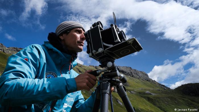 Ein Fotograf mit einer nachgebauten historischen Kamera in den italienischen Alpen am Gletscher Marmolada