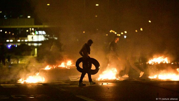 Young men burning tires in the street at night