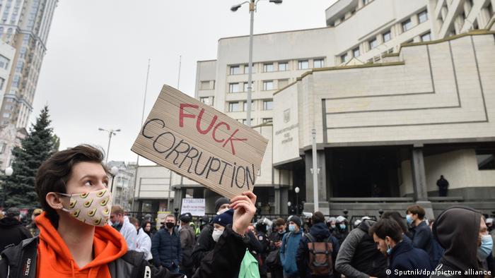 Протестувальник із плакатом, на якому написано Fuck corruption, під час акції біля будівлі Конституційного суду України в Києві, фото 30 жовтня 2020 року