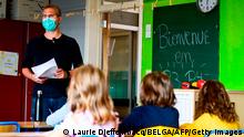 A teacher with a protective mask speak to the pupils in a classroom in Saint-Gilles - Sint-Gillis, in Brussels, on September 1, 2020 on the first day of school amid Covid-19 epidemic. - schools across Europe open their doors to greet returning pupils this month, nearly six months after the coronavirus outbreak forced them to close and despite rising infection rates across the continent. (Photo by LAURIE DIEFFEMBACQ / BELGA / AFP) / Belgium OUT (Photo by LAURIE DIEFFEMBACQ/BELGA/AFP via Getty Images)
