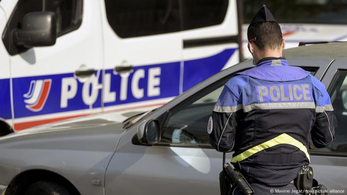 A French policeman in front of a car