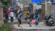 Kashmiri protesters throw stones towards the government forces on the outskirts of Srinagar