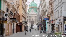 A man walks along the empty street Kohlmarkt among luxury shops closed, as the Michael Dome of the Vienna Hofburg stands in the background, in the center of Vienna on November 03, 2020, after the multiple shootings leaving four people dead on the eve occurred in the Austrian capital. - One of the gunmen in the Vienna attack which left four people dead had double North Macedonian-Austrian nationality and a conviction for trying to travel to Syria, the interior minister said November 3, 2020. (Photo by ALEX HALADA / AFP) (Photo by ALEX HALADA/AFP via Getty Images)