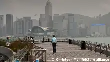 die Uferpromenade am Tsim Sha Tsui Ferry und die Skyline von Hongkong Island mit dem Hongkong Convention Center ein Polizei Hubschrauber fliegt am Himmel | Verwendung weltweit