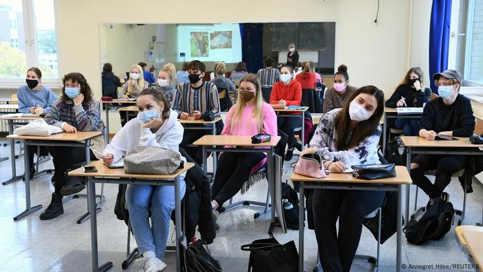 Germany |  Corona virus: masks are compulsory in schools.  Older young people sit in a classroom at individual tables and wear mouth and nose protection
