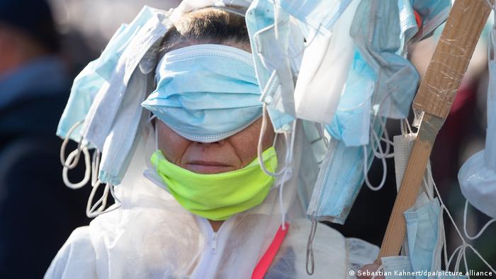 A coronavirus denier at a protest in Leipzig wearing masks everywhere but her mouth
