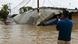 Man stands in front of a property destroyed by the storm Man stands in front of a property destroyed by the storm