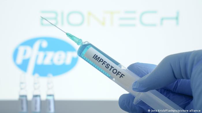 Шприц с надписью вакцина на фоне названий фирм Biontech и Pfizer 