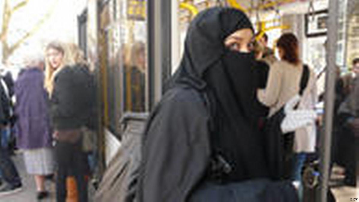 A Muslim lady wearing a Niqab passes the luxury shop window of