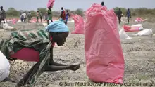 FILE - In this Wednesday, May 2, 2018 file photo, a woman scoops fallen sorghum grain off the ground after an aerial food drop by the World Food Program (WFP) in the town of Kandak, South Sudan. The World Food Program on Friday, Oct. 9, 2020 won the 2020 Nobel Peace Prize for its efforts to combat hunger and food insecurity around the globe. (AP Photo/Sam Mednick, File) |