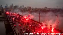 Polish far-right supporters hold flags and light flares as they cross the Poniatowski bridge during a march through the centre of Warsaw to mark the country's Independence Day, November 11, 2020. (Photo by Wojtek RADWANSKI / AFP) (Photo by WOJTEK RADWANSKI/AFP via Getty Images)