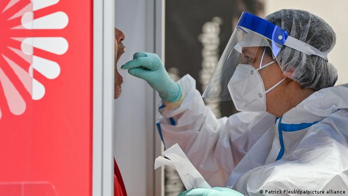 A worker administers a coronavirus test at the Berlin Brandenburg Airport