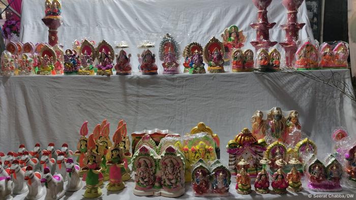 A street vendor displays small idols of Hindu gods and goddesses (Seerat Chabba/DW)