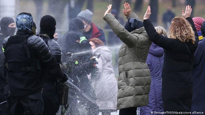  Law enforcement officers spraying protesters at a demonstration in Minsk