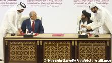 ARCHIV - 29.02.2020, Katar, Doha: Zalmay Khalilzad (2.v.l), US-Sondergesandter für Aussöhnung in Afghanistan, und Mullah Abdul Ghani Baradar (2.v.r), Leiter des politischen Büros der Taliban, unterzeichnen ein Abkommen über Wege zu einem Frieden zwischen den USA und der militant-islamistischen Taliban. (zu dpa «Nach US-Wahl: Taliban pochen auf Umsetzung des Deals mit Amerikanern») Foto: Hussein Sayed/AP/dpa +++ dpa-Bildfunk +++ |
